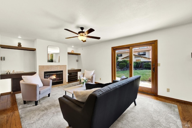 living area with recessed lighting, a fireplace, ceiling fan, baseboards, and wood finished floors