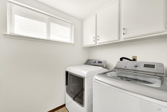 clothes washing area featuring washer and dryer and cabinet space