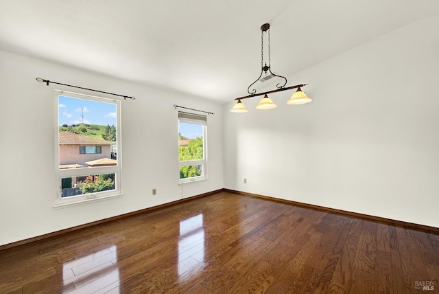 empty room featuring baseboards and wood finished floors