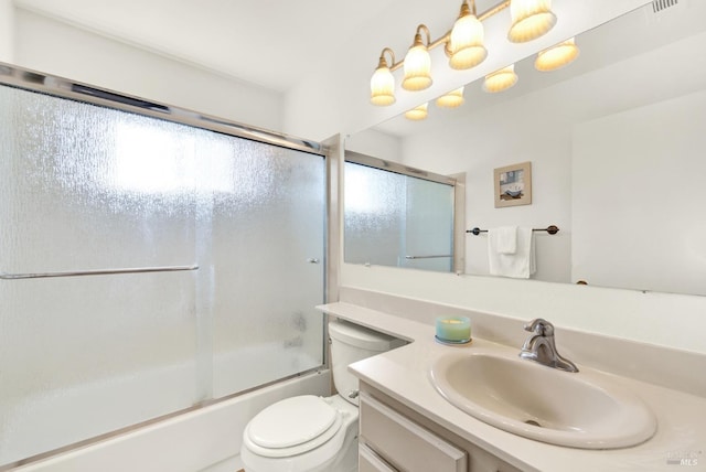 full bathroom featuring bath / shower combo with glass door, vanity, and toilet
