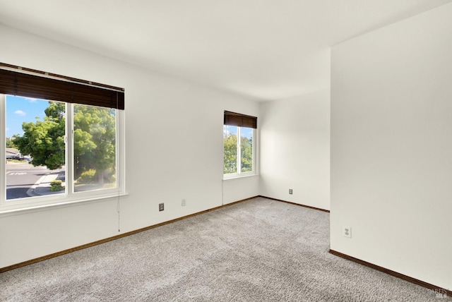 carpeted empty room with baseboards