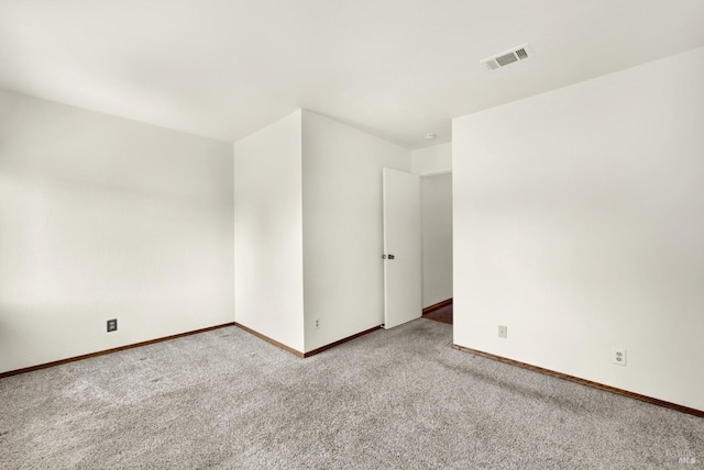 spare room featuring baseboards, visible vents, and carpet floors