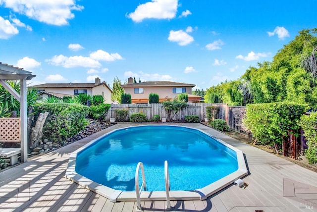 view of pool featuring a deck, a fenced backyard, and a fenced in pool