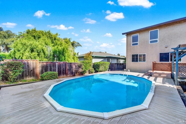 view of pool featuring a deck, a pergola, and a fenced backyard