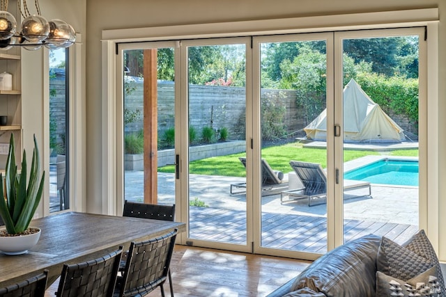 doorway to outside with an inviting chandelier and wood finished floors
