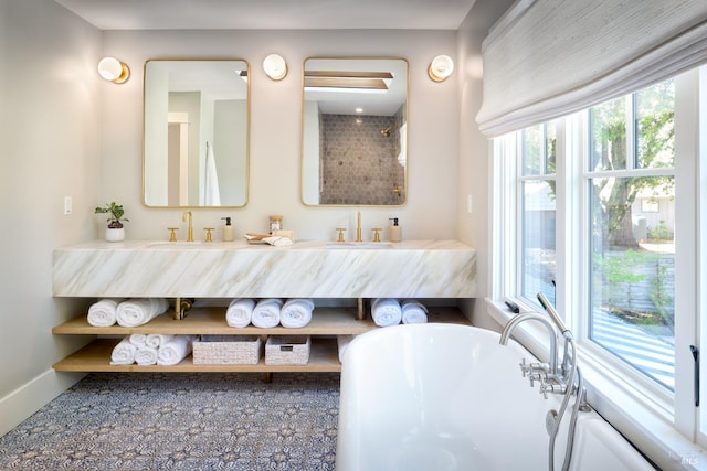 bathroom featuring double vanity, a sink, and a freestanding tub