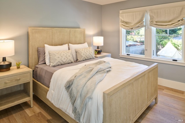 bedroom with baseboards and light wood-type flooring