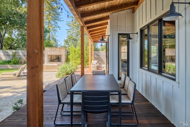 wooden terrace featuring outdoor dining space and a fenced backyard