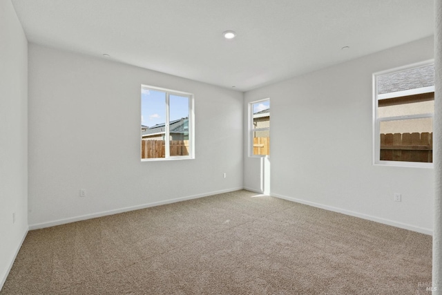 spare room with light colored carpet and baseboards