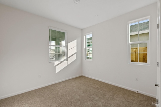 empty room with a healthy amount of sunlight, carpet flooring, and baseboards