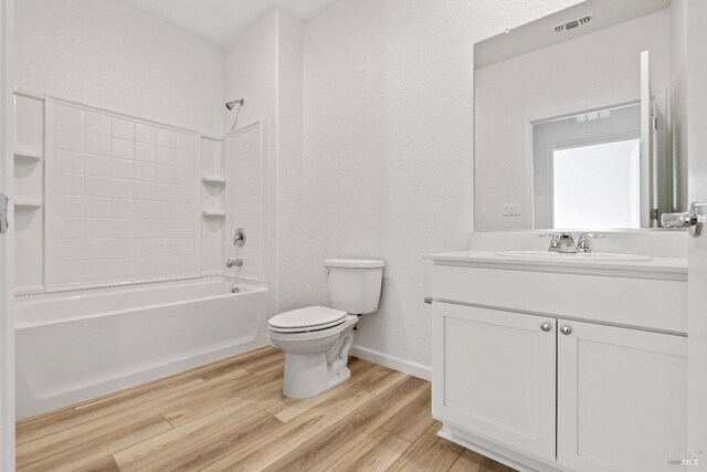 bathroom featuring vanity, bathing tub / shower combination, toilet, visible vents, and wood finished floors