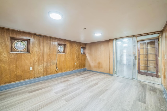 empty room featuring wooden walls and wood finished floors