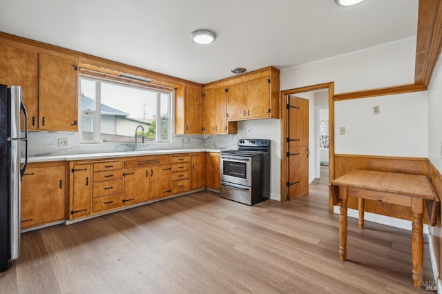 kitchen featuring light wood-style floors, stainless steel appliances, and light countertops