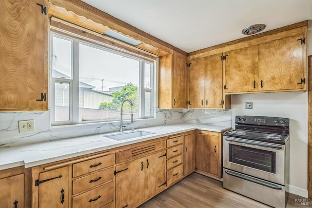 kitchen with decorative backsplash, a sink, stainless steel electric stove, visible vents, and wood finished floors