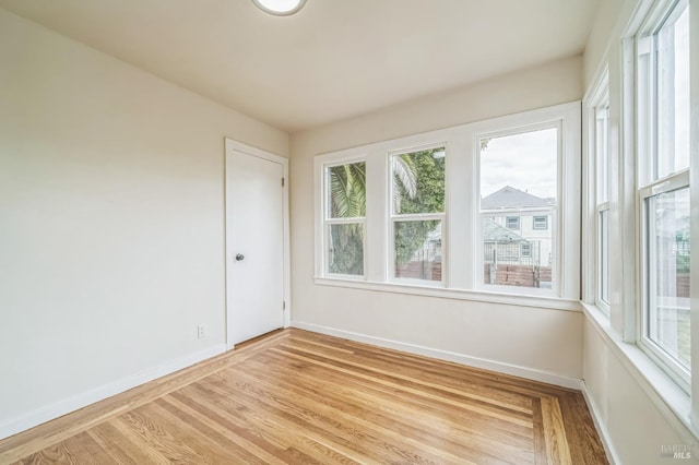 empty room with light wood-style flooring and baseboards