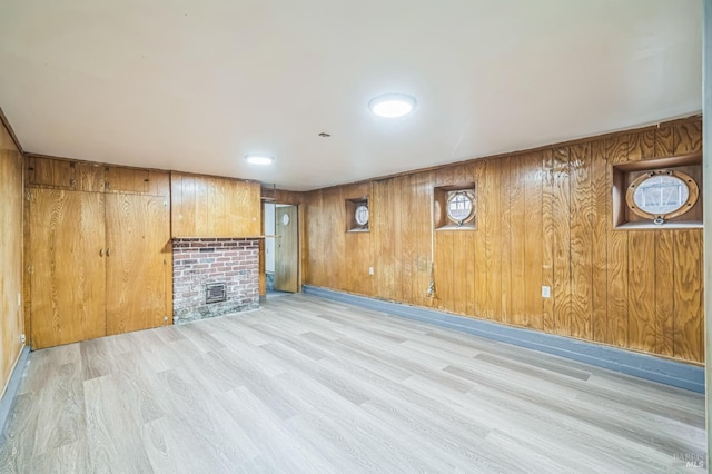below grade area with wood walls, wood finished floors, and a fireplace
