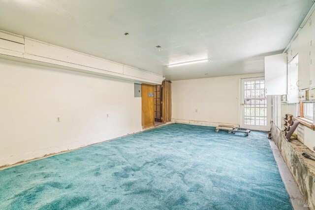 unfurnished room featuring electric panel and light carpet