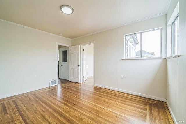 interior space with ornamental molding, visible vents, baseboards, and light wood-type flooring