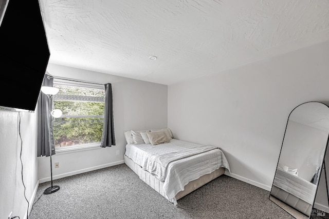 bedroom featuring baseboards, a textured ceiling, and carpet flooring