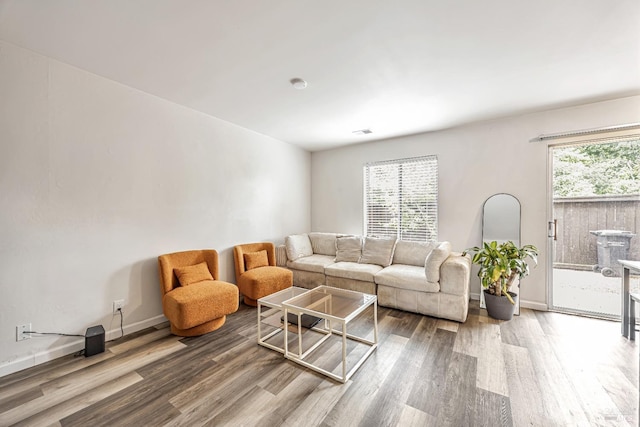 living room with visible vents, wood finished floors, and baseboards