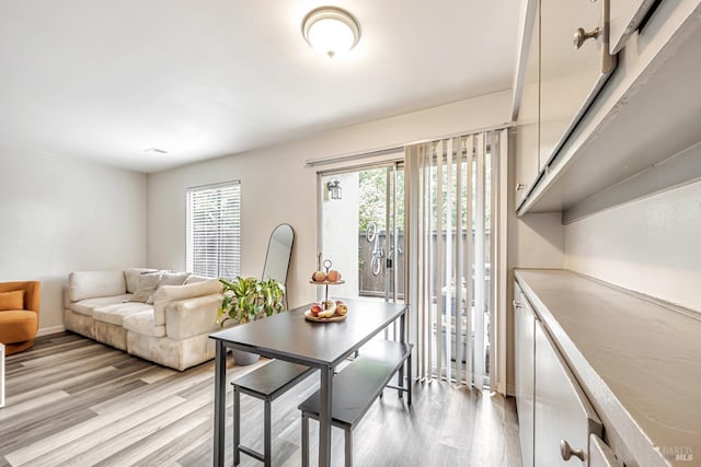 dining area featuring light wood finished floors and baseboards