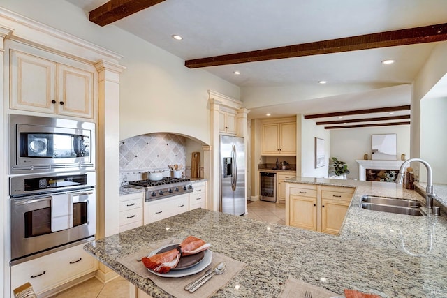kitchen with stainless steel appliances, beamed ceiling, backsplash, a sink, and wine cooler