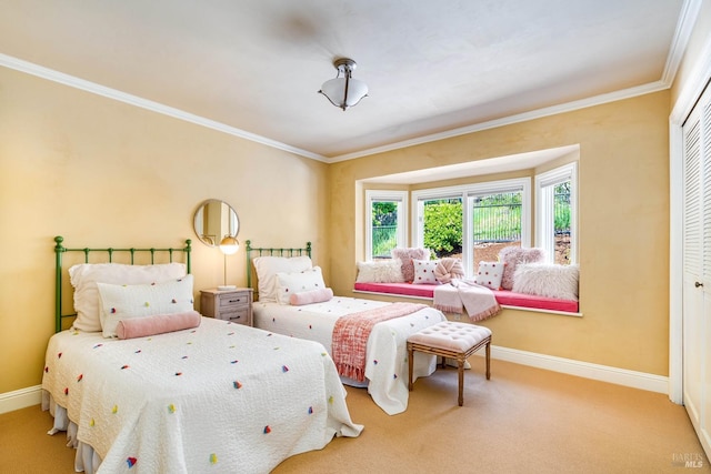 carpeted bedroom with ornamental molding, a closet, and baseboards