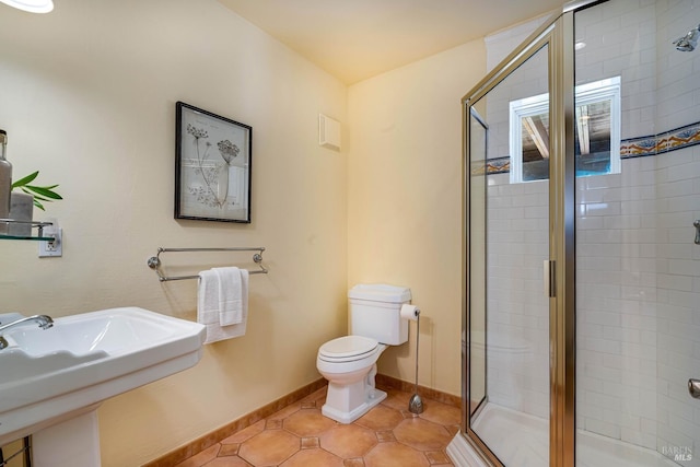 full bathroom featuring toilet, a stall shower, tile patterned floors, and baseboards