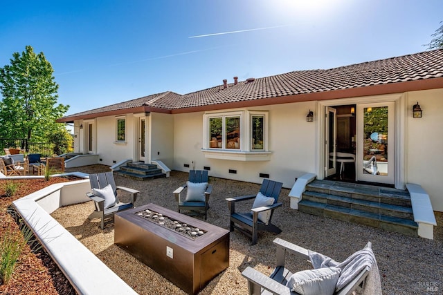 back of house with a patio area, stucco siding, a tiled roof, a fire pit, and entry steps