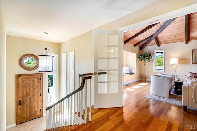 entrance foyer featuring wood ceiling, light wood finished floors, vaulted ceiling with beams, and baseboards