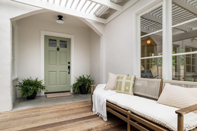 property entrance featuring stucco siding and a pergola