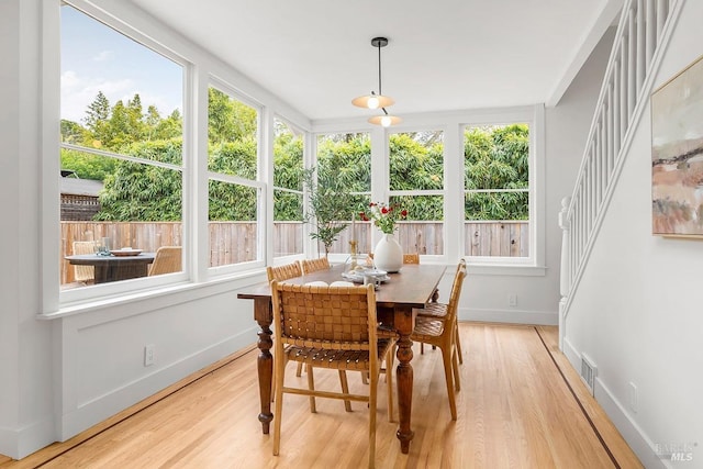 sunroom with wood finished floors, plenty of natural light, and baseboards