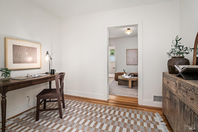 office area with visible vents, wood finished floors, and baseboards