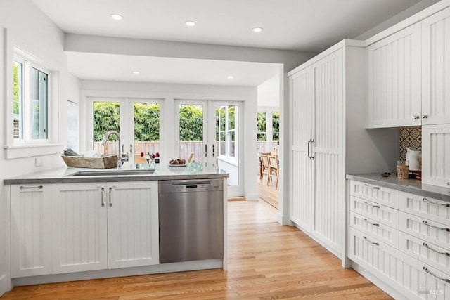 kitchen featuring recessed lighting, dishwasher, light wood finished floors, a sink, and french doors