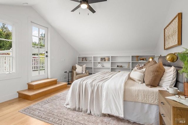 bedroom with wood finished floors, a ceiling fan, vaulted ceiling, and access to outside