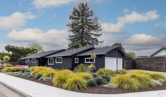 view of side of property featuring an attached garage and fence
