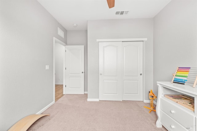 interior space with visible vents, baseboards, a closet, and light carpet