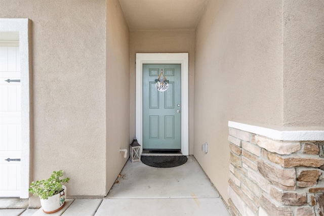entrance to property featuring stucco siding