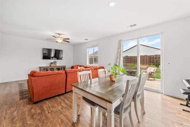 dining area with ceiling fan, visible vents, baseboards, and light wood finished floors
