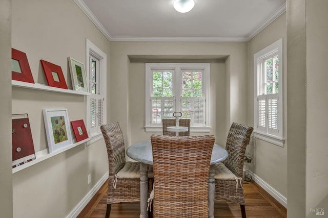 dining space with ornamental molding, wood finished floors, and baseboards