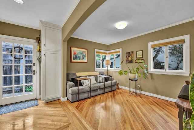 living area featuring ornamental molding, light wood finished floors, and baseboards