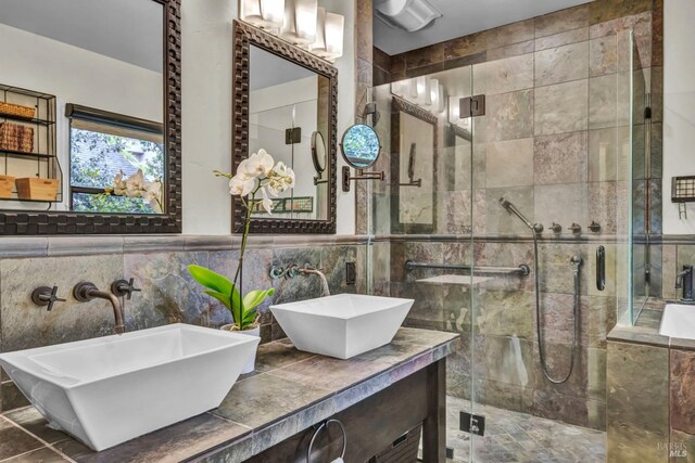 bathroom featuring tile walls, a stall shower, and a sink