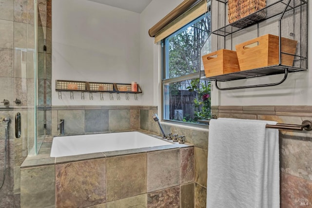bathroom with a bath and tiled shower