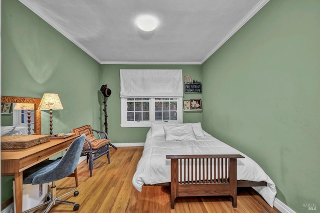 bedroom with baseboards, wood finished floors, and crown molding