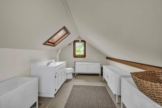 additional living space featuring vaulted ceiling with skylight and a sink