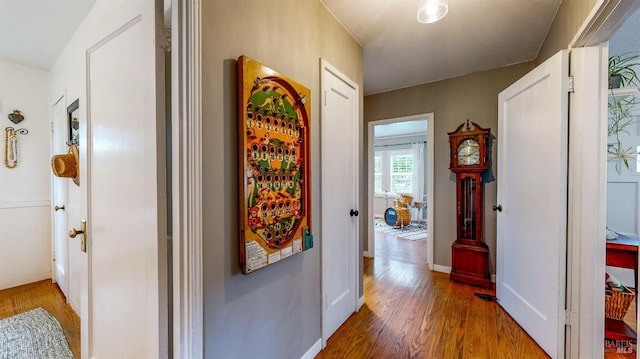 corridor with baseboards and wood finished floors