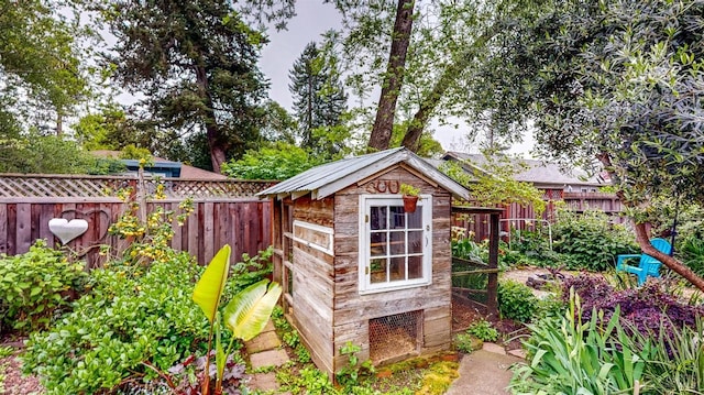 view of outdoor structure with a fenced backyard and an outbuilding