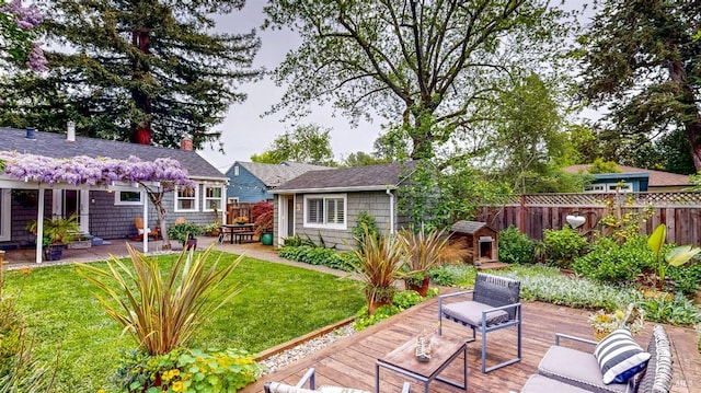exterior space featuring a chimney, an outdoor structure, fence, a patio area, and a lawn