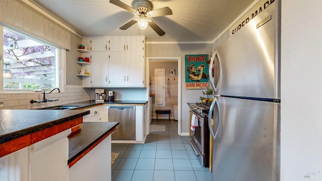 kitchen with a sink, stainless steel appliances, open shelves, dark countertops, and white cabinets