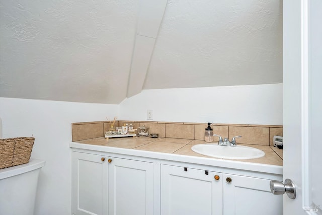 bathroom with vanity, vaulted ceiling, and toilet
